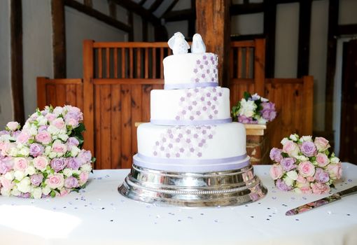 Wedding cake on table at reception with flowers