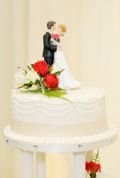 Wedding cake with bride and groom topper closeup detail
