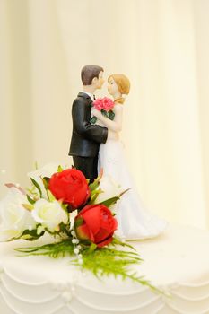 Wedding cake closeup shows topper of bride and groom