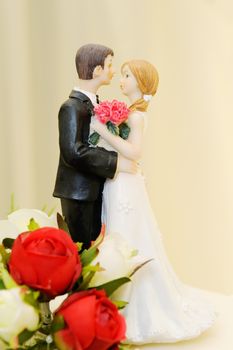 Wedding cake topper shows bride and groom in embrace