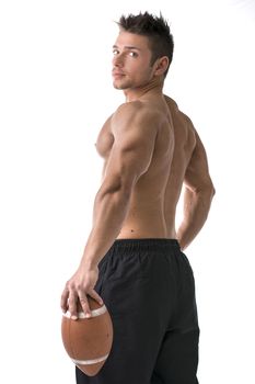 Muscular american football player standing with ball in hand, seen from the back, isolated