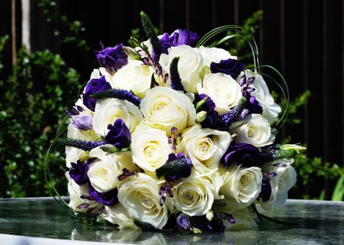 Brides arrangement of purple flowers and white roses on wedding day