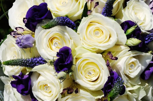 Brides white rose and purple flower closeup on wedding day