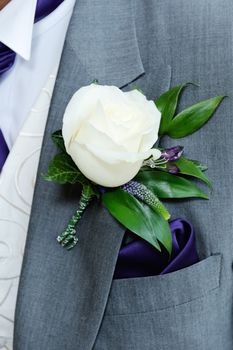 Grooms buttonhole closeup is white roseon wedding day