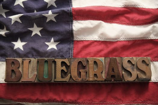 an American flag with the word bluegrass in old wood type