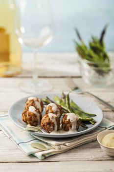 Tasty meatballs in white sauce with sage and green beans
