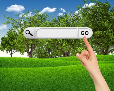 Human hand indicates the search bar in browser. Green grass and clouds on background
