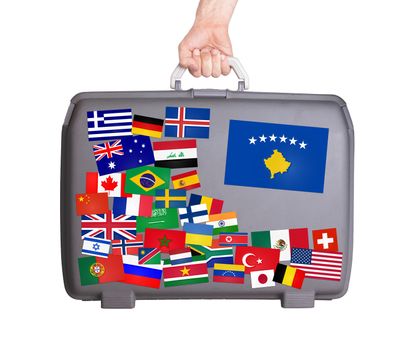 Used plastic suitcase with lots of small stickers, large sticker of Kosovo