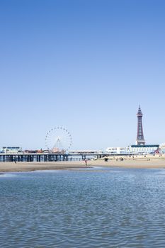 View across the sea of the waterfront and beach with the Blackpool Tower and piers, Blackpool, England