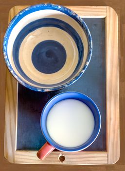 pottery bowl and cup milk on the blackboard background