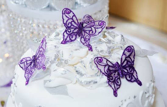 White wedding cake with purple butterfly decoration