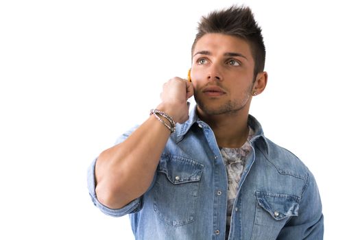 Handsome young man talking on cell phone (mobile), isolated on white. Looking off-camera