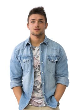 Handsome young man standing with open denim shirt, looking at camera, isolated