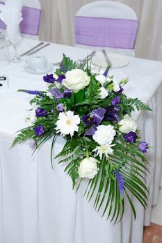 Purple and white flowers decorate table at wedding reception