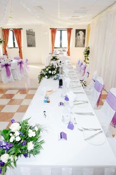 Table with white and purple flowers decorate wedding reception