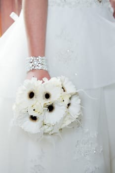 Bride on wedding holding white bunch of flowers