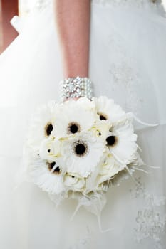 Closeup detail of bride holding white bouquet