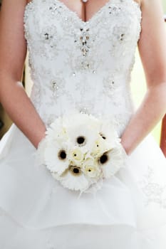 Brides white flower arrangement and dress detail closeup