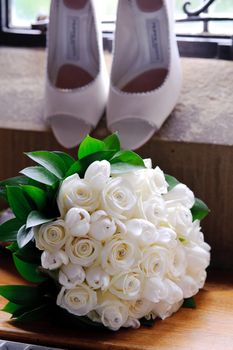 Brides flowers with shoes in the background at wedding