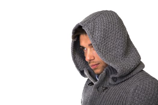Good looking young man wearing winter hoodie sweater, looking to a side. Large copyspace