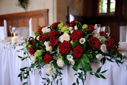 Red roses decorate head table at a wedding