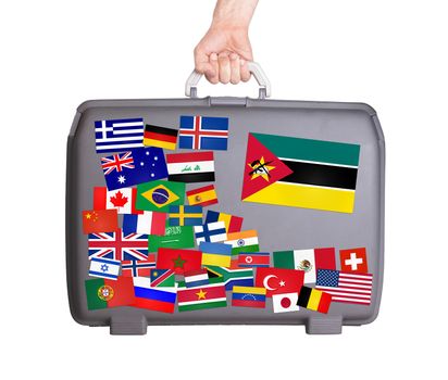 Used plastic suitcase with lots of small stickers, large sticker of Mozambique