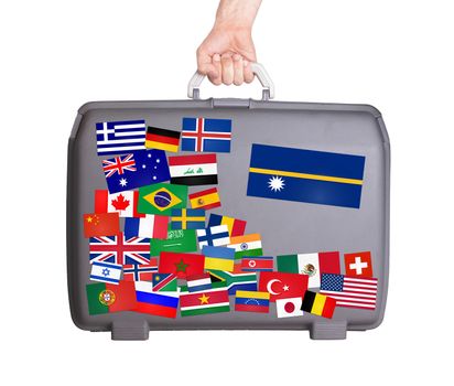Used plastic suitcase with lots of small stickers, large sticker of Nauru