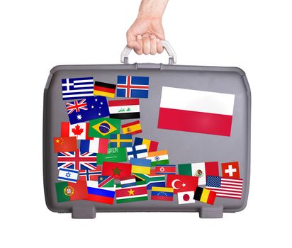 Used plastic suitcase with lots of small stickers, large sticker of Poland