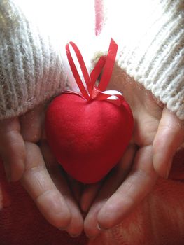 Valentine red heart in woman tender hands