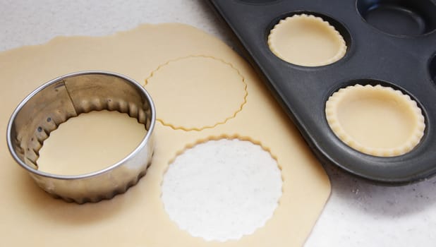 Cutting large circles of pastry to line a bun tin