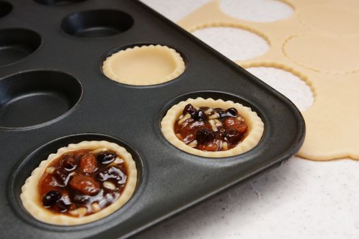 Making mince pies - pastry cases filled with traditional mincemeat