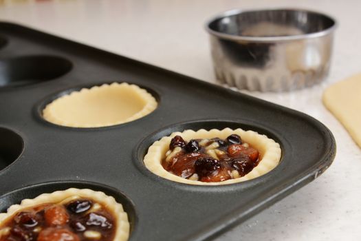 Closeup of pastry case filled with traditional mincemeat, with cutter beyond