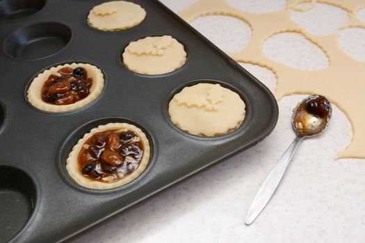 Making mince pies, with rolled out pastry scraps and teaspoon of mincemeat