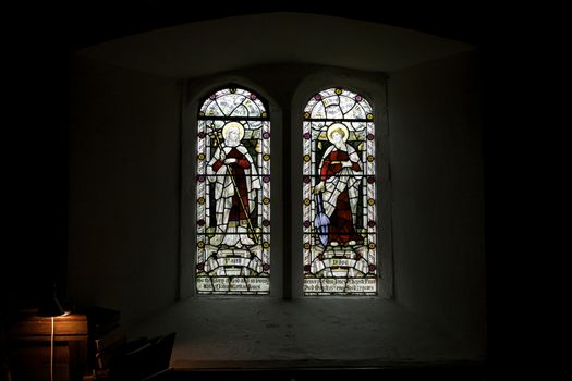 Religious stain glass windows with two panels inside the church