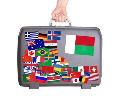 Used plastic suitcase with lots of small stickers, large sticker of Madagascar