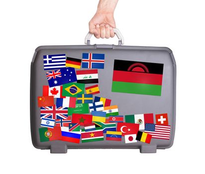 Used plastic suitcase with lots of small stickers, large sticker of Malawi