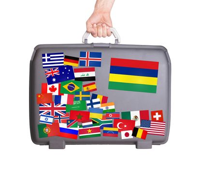 Used plastic suitcase with lots of small stickers, large sticker of Mauritius