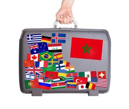 Used plastic suitcase with lots of small stickers, large sticker of Morocco