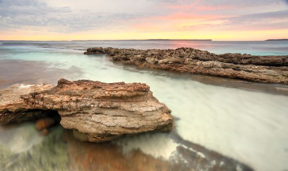 Pastel colours of a surreal sunrise at Hyams Beach at Jervis Bay, Australia.  Long exposure