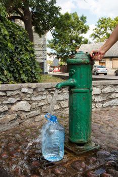 A green public water sink in a city