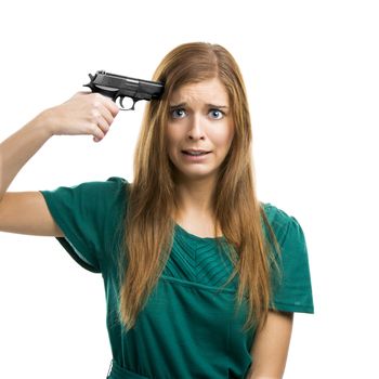 Portrait of a beautiful girl with pointing a gun on herself isolated on white background