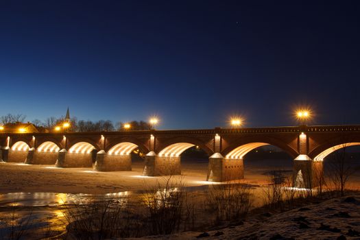 Frozen river Venta and old brick bridge in Kuldiga, Latvia
