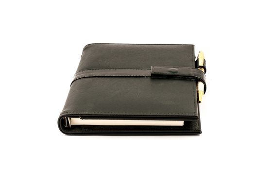 Black note book with ballpoint pen on white background