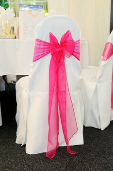 Pink chair cover at wedding reception