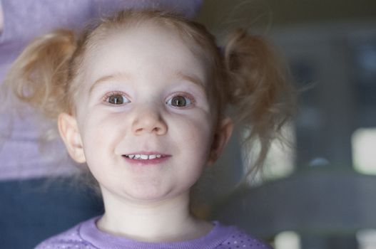 Pretty little redhead girl with a cute expression looking at the camera with parted lips and an amused look in her eyes