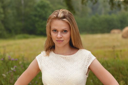 Sexy girl blonde on a green background of the nature