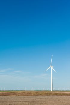 Sustainable wind energy generators against blue sky; renewable energy that helps fight against global warming