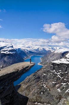 Hiker gazing at nature around Trolltunga rock in Norway