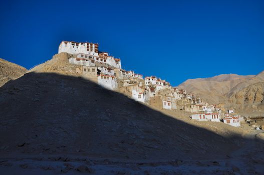 Side view of the sunlit Chemrey monastery in the setting sun   