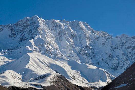 Sunlit mountains covered in snow between Mestia and Ushguli